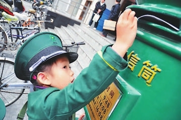 小孩扮演邮递员到邮政局了解邮递服务  资料图片